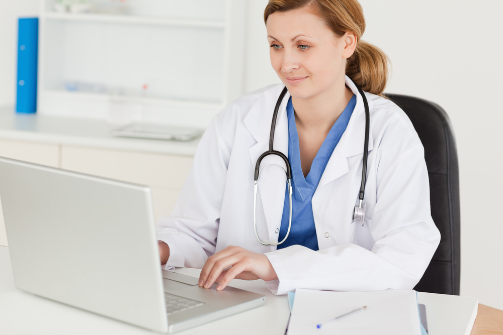 Attractive female doctor working on her laptop in her office Attractive female doctor working on her laptop in her office