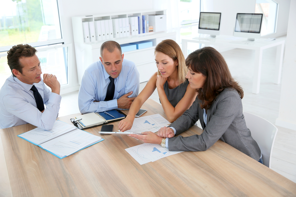 Group of business people meeting around table with tablet Group of business people meeting around table with tablet